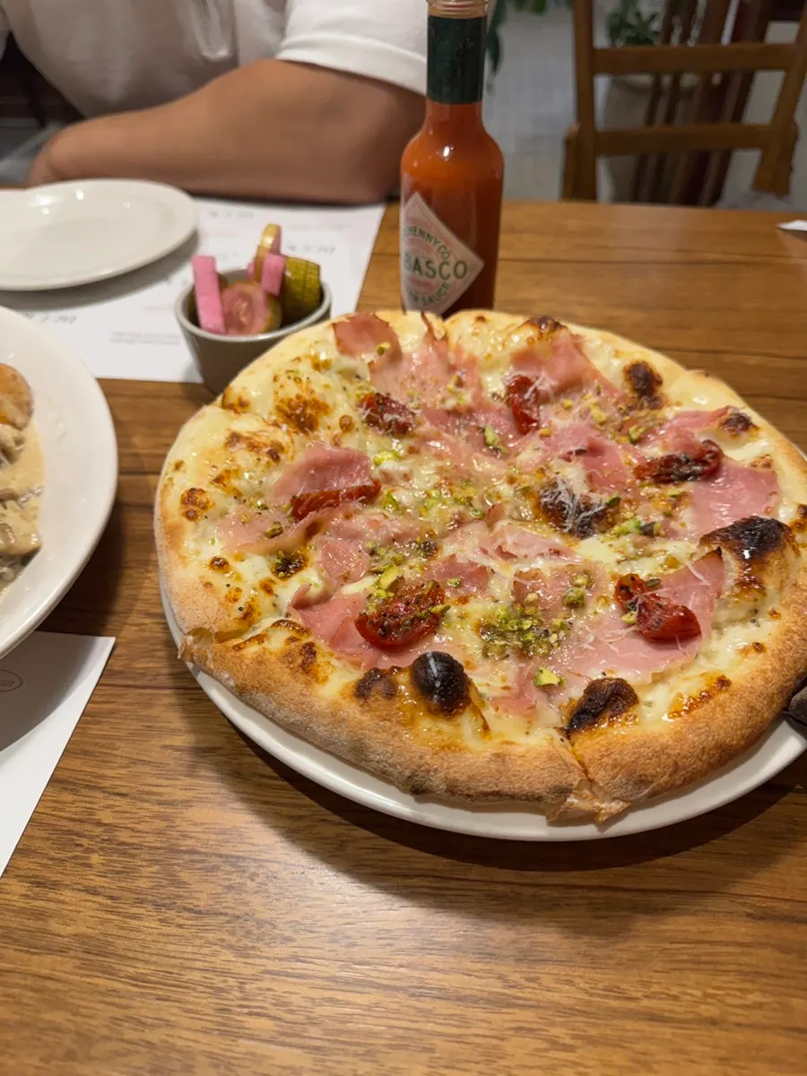 Jambon pizza topped with pistachios