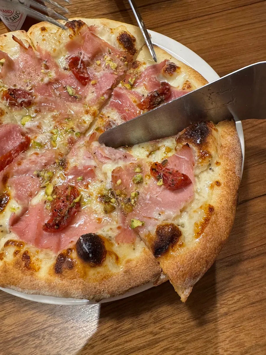 A slice of pizza topped with jambon