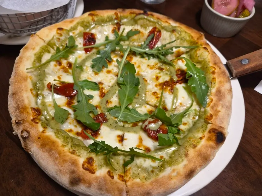 Basil margherita pizza topped with basil and mozzarella