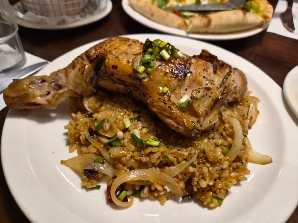 Kung pao chicken pilaf topped with a whole chicken leg