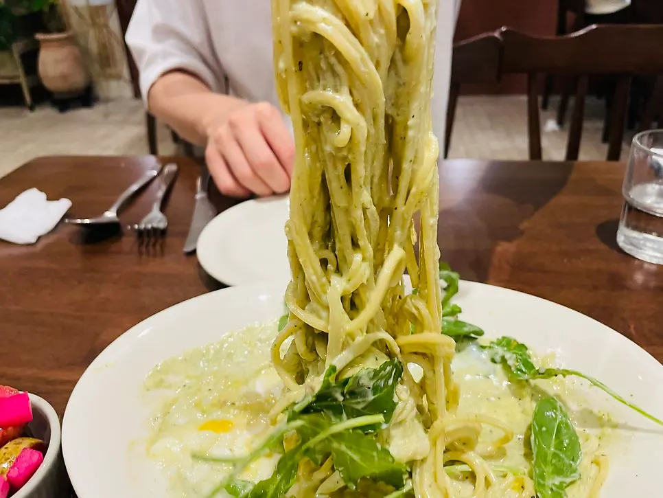 Basil pesto cream pasta noodles twirled on a fork