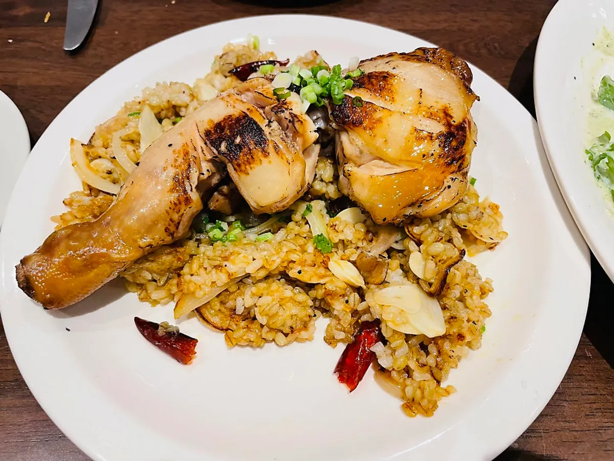 Kung pao chicken pilaf topped with a large chicken drumstick