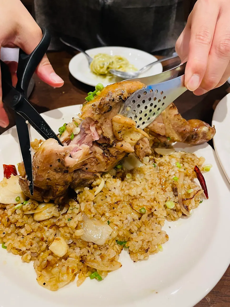 Chicken leg broken down with tongs and scissors