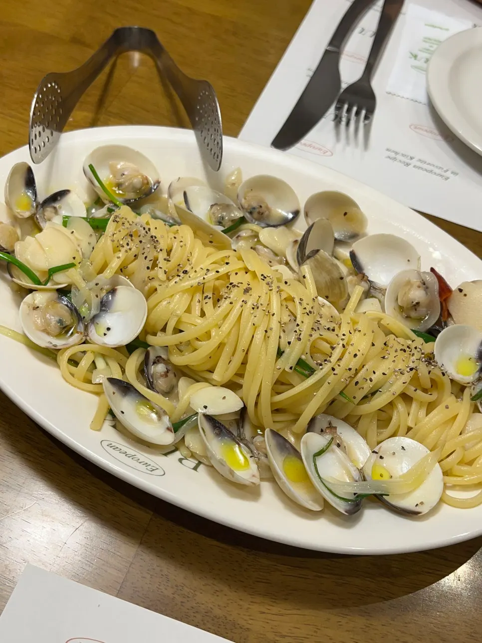 A table spread of vongole pasta, pizza, and pastry soup