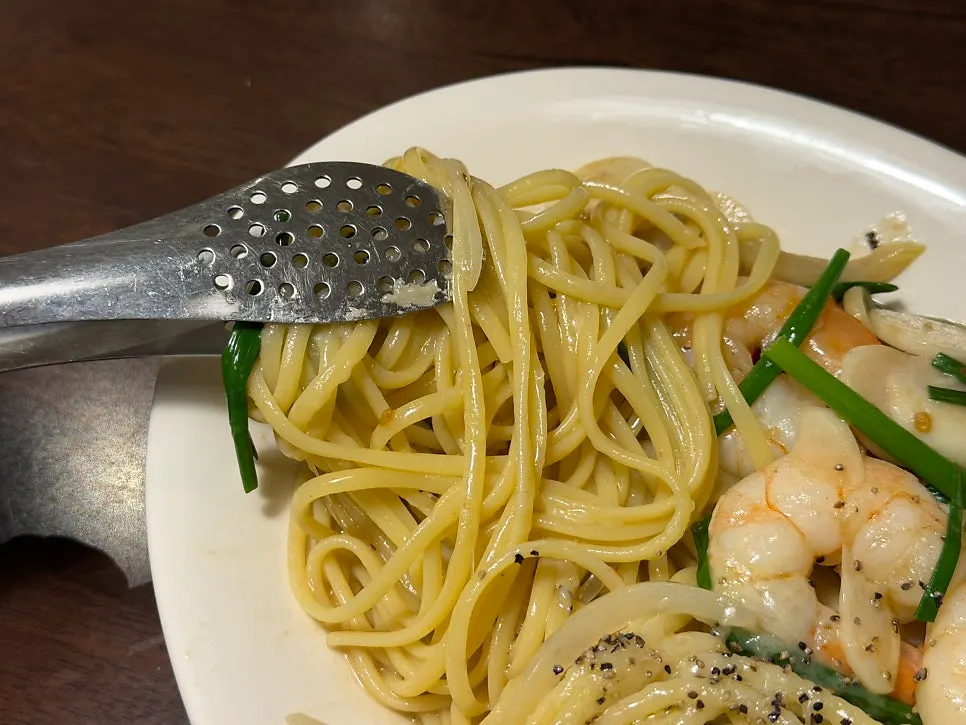 Plump shrimp and sliced garlic visible in the anchovy pasta