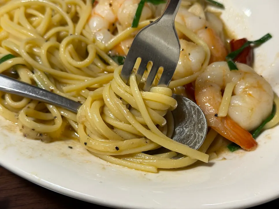 Fork lifting noodles from the anchovy oil pasta
