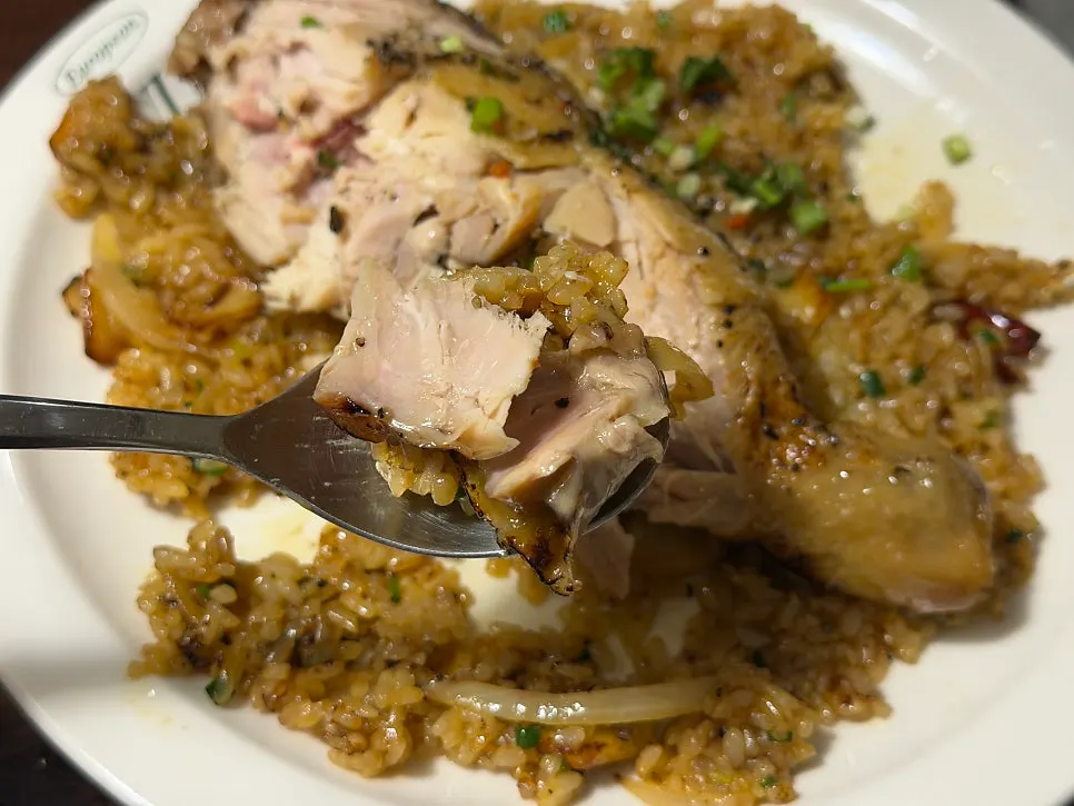 Whole oven-roasted chicken placed on top of fried rice