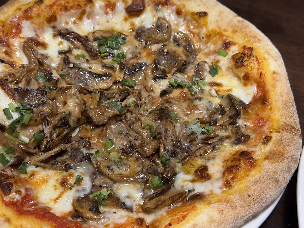 A slice of truffle mushroom pizza with stretching cheese