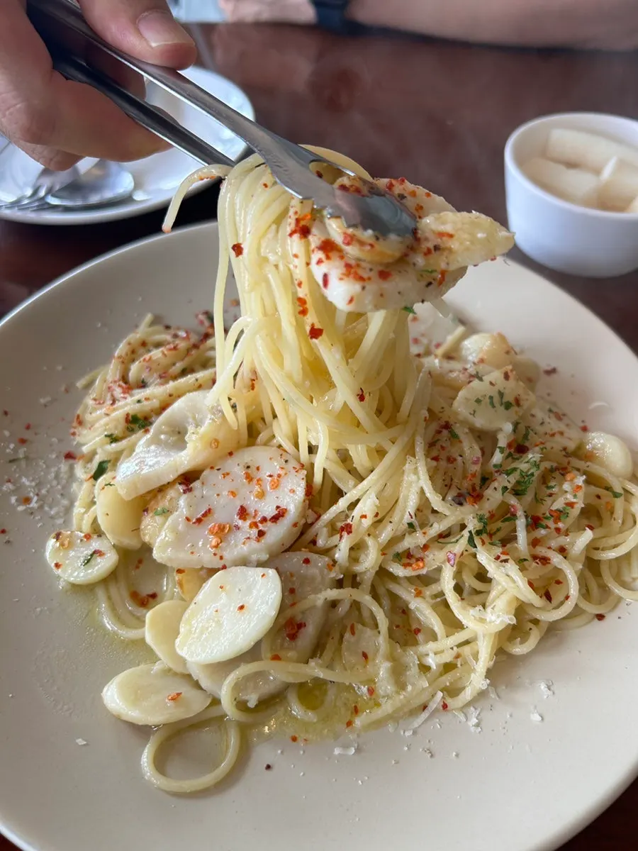 Scallop aglio e olio with small tongs
