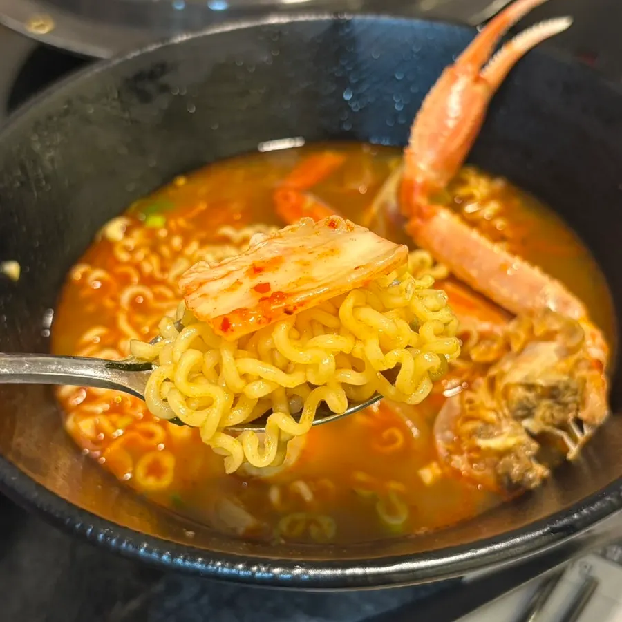 A bite of ramyeon with kimchi on top