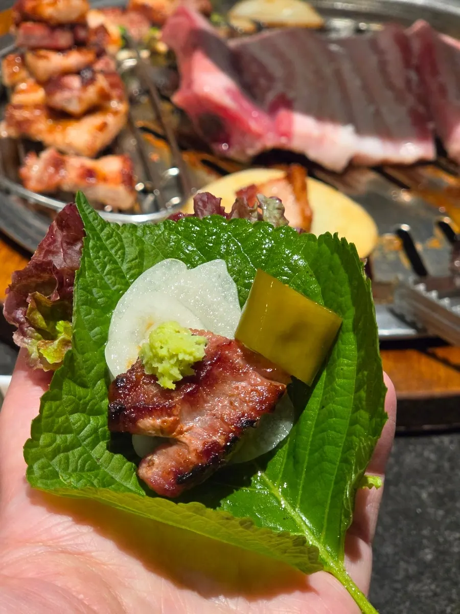 A bite of rib wrap with pickled radish and onion