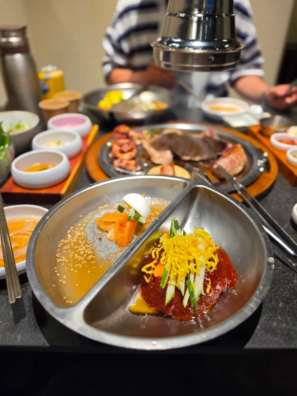 Water naengmyeon and mixed naengmyeon served together in one bowl