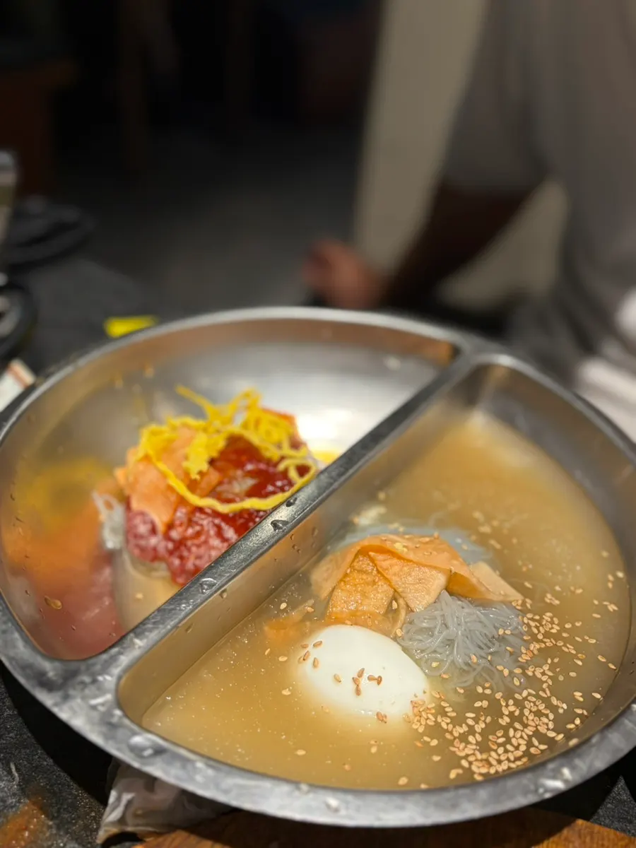 Half-and-half naengmyeon served in a divided bowl