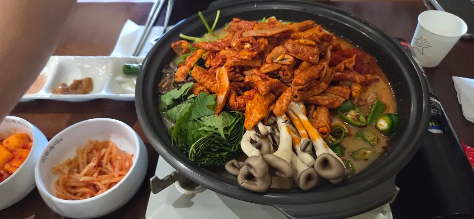 Pork gopchang pieces scooped from the bubbling hot pot