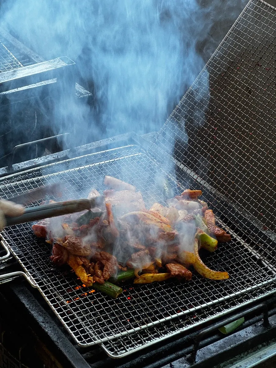 Duck being pre-grilled over charcoal