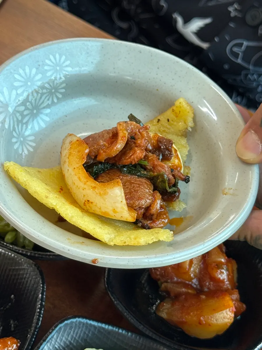 A piece of duck jumulleok on a lettuce wrap