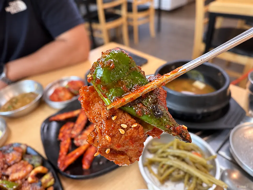 A bite combining meat, squid, and scallion