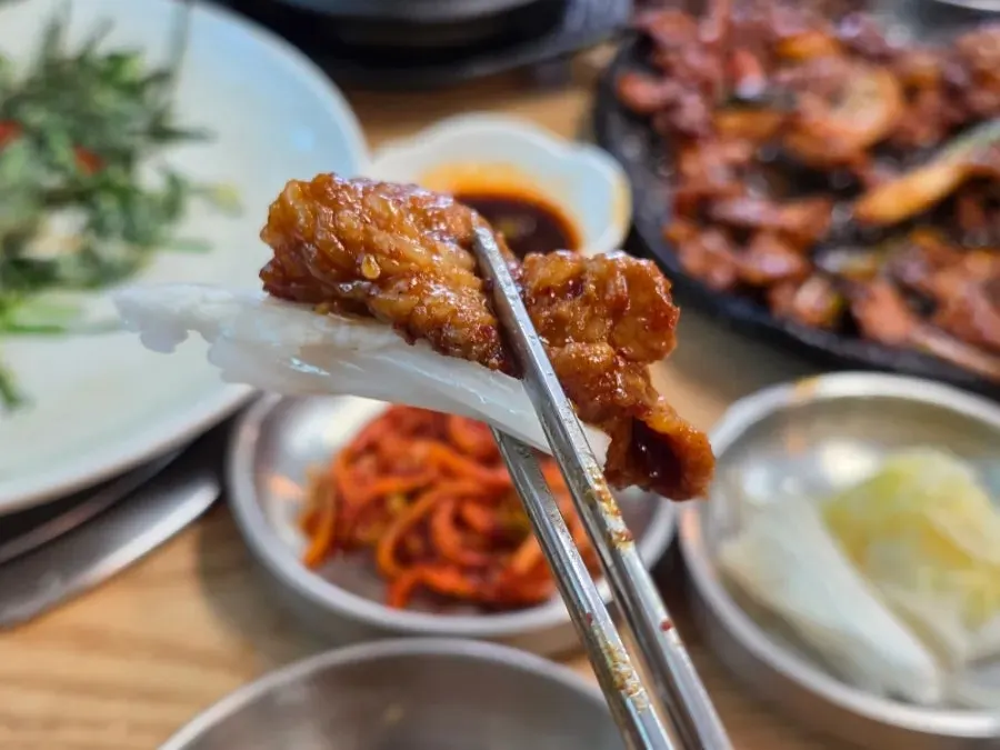 Close-up of black pork grilled over a charcoal briquette fire