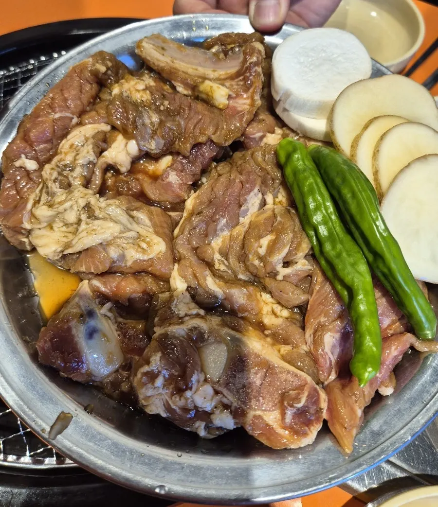 Charcoal marinated ribs grilling on the pan