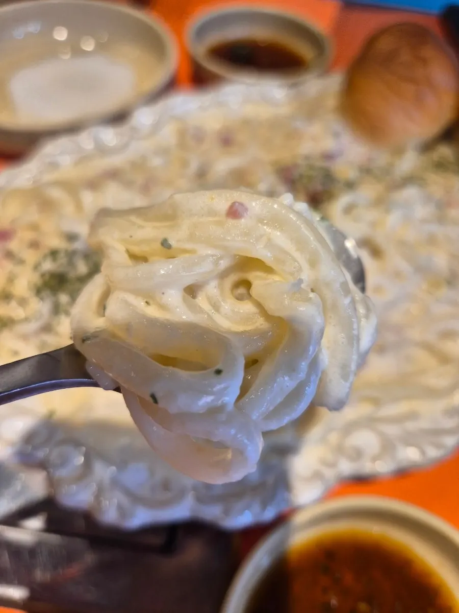 Lifting up noodles from the creamy Cheongyang cream udon sauce