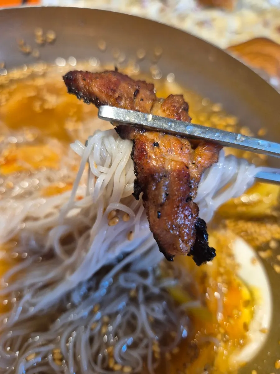 Lifting up a strand of mul-naengmyeon noodles