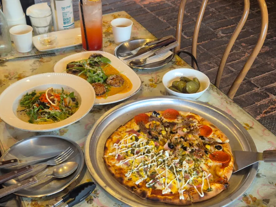 Half-and-half pizza and snow crab guts cream pasta table spread