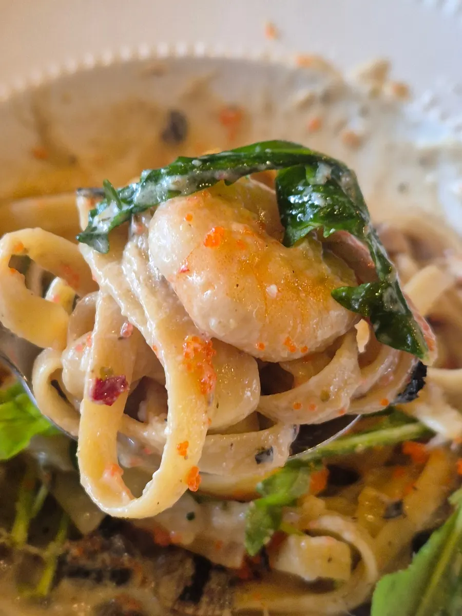 Snow crab guts cream pasta noodles twirled on a fork