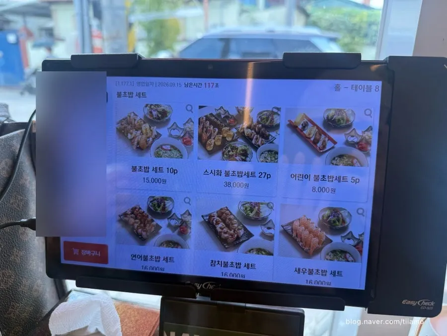 스시화 메뉴판을 펼쳐 본 테이블