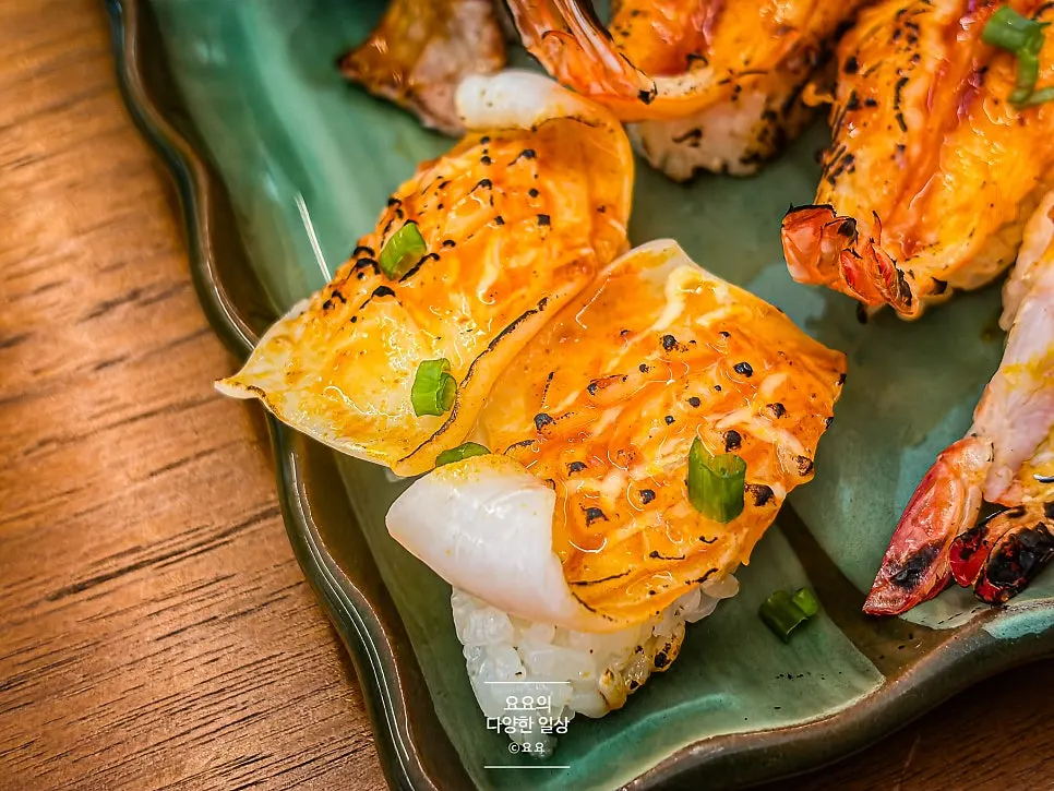 Flame-seared sushi topped with spicy sauce