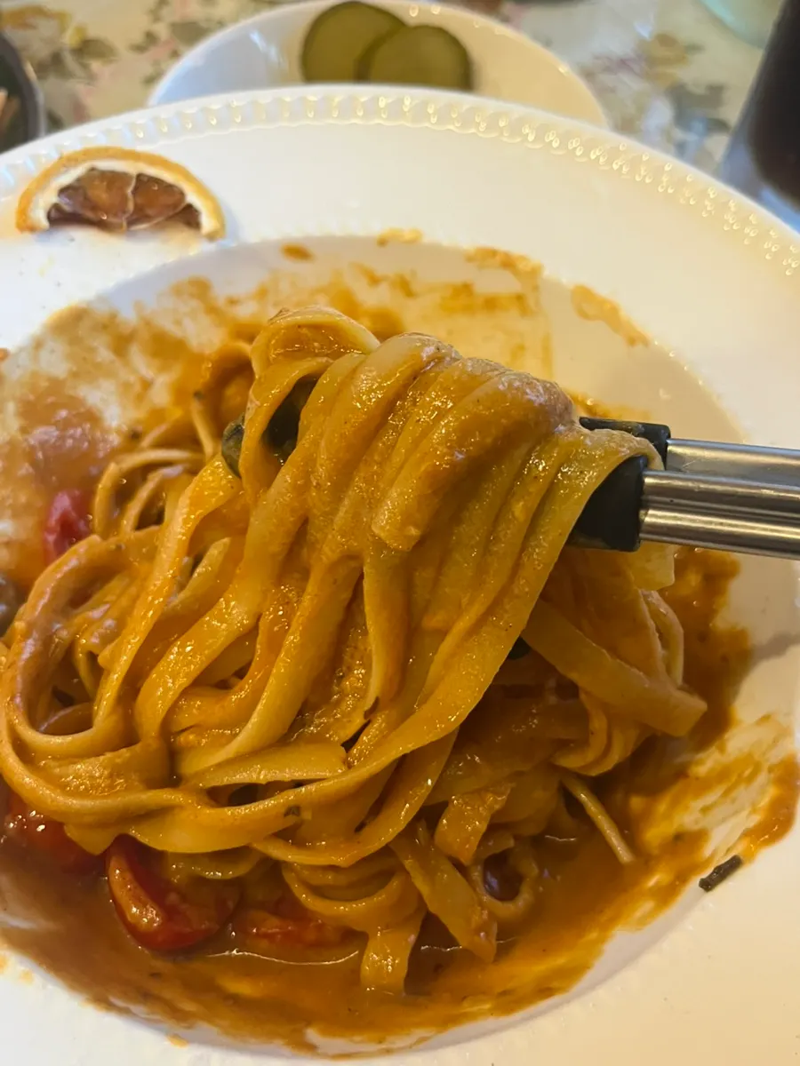 Close-up of bisque pasta topped with tomato and red shrimp meat