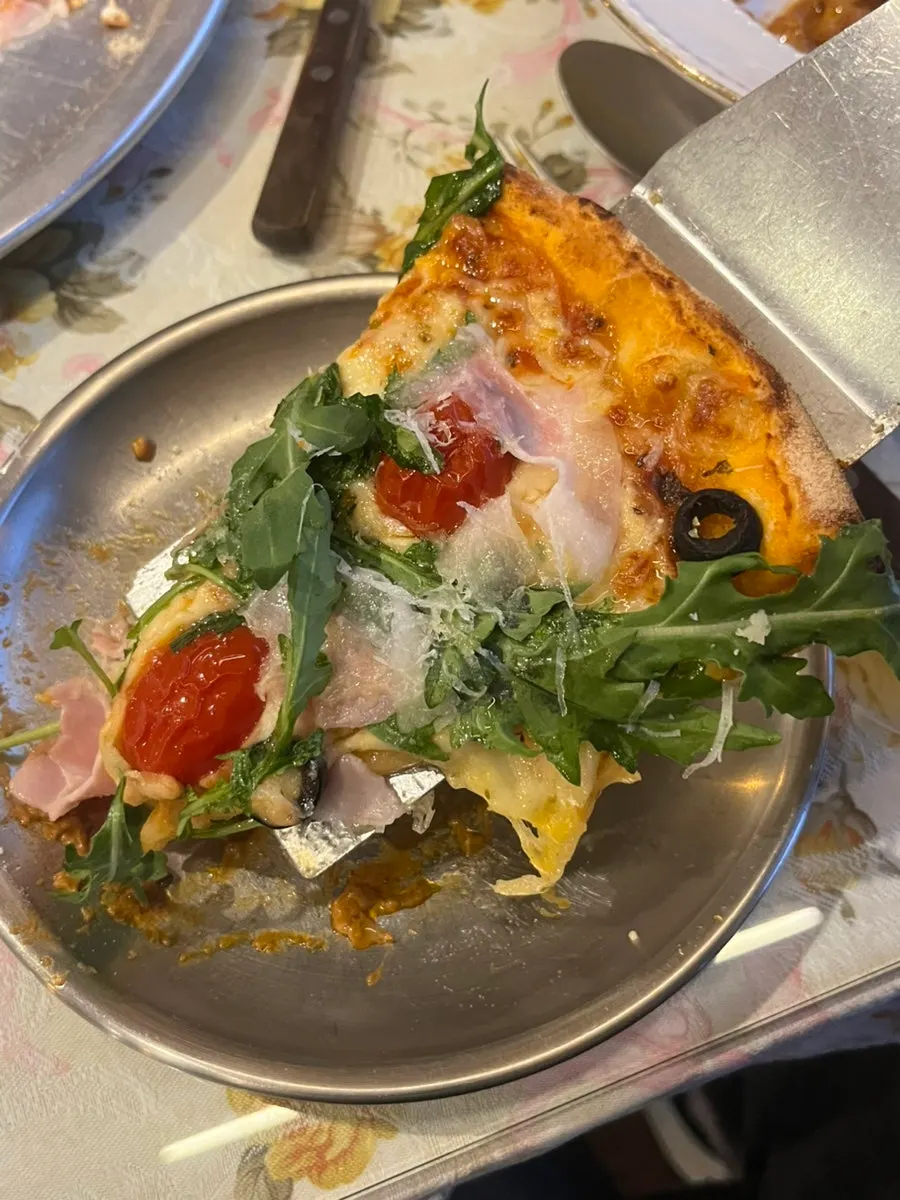 Close-up of fresh arugula and jambon on the pizza