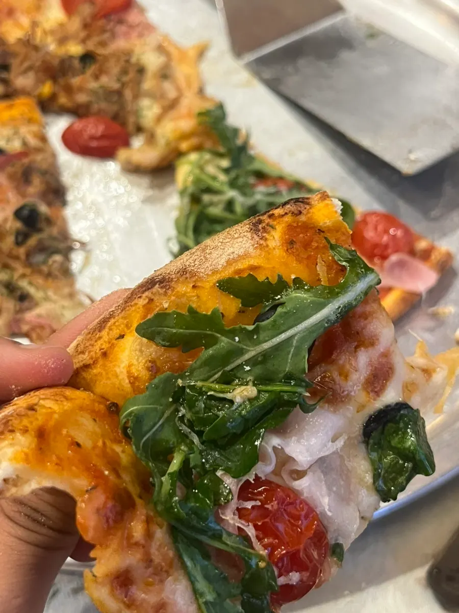 Cross-section of the jambon pizza showing mozzarella cheese and olives