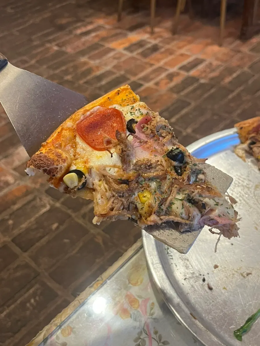 Combination pizza showing pepperoni, ham, and olives
