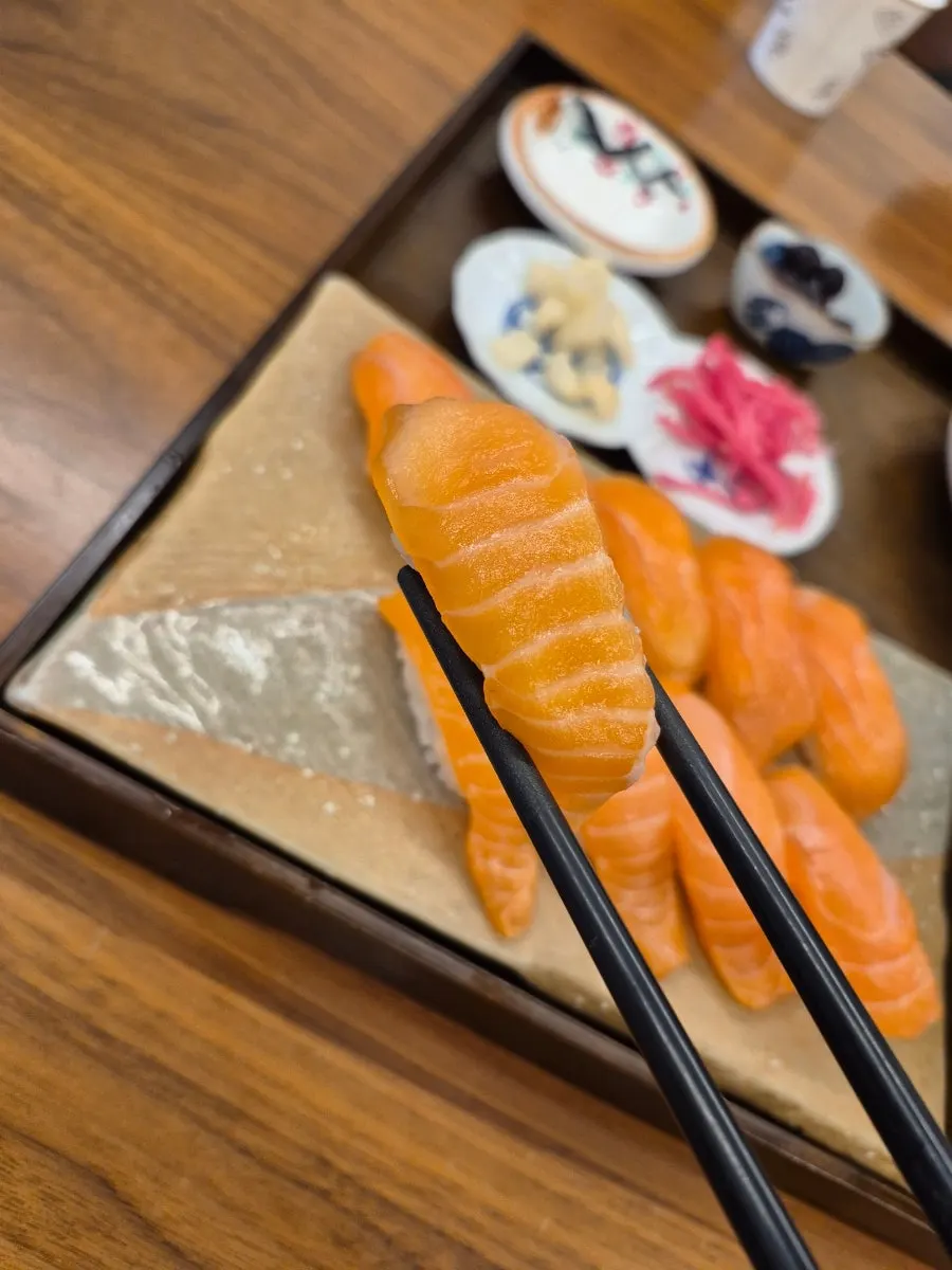 한 입 크기로 올려진 생연어 초밥 클로즈업