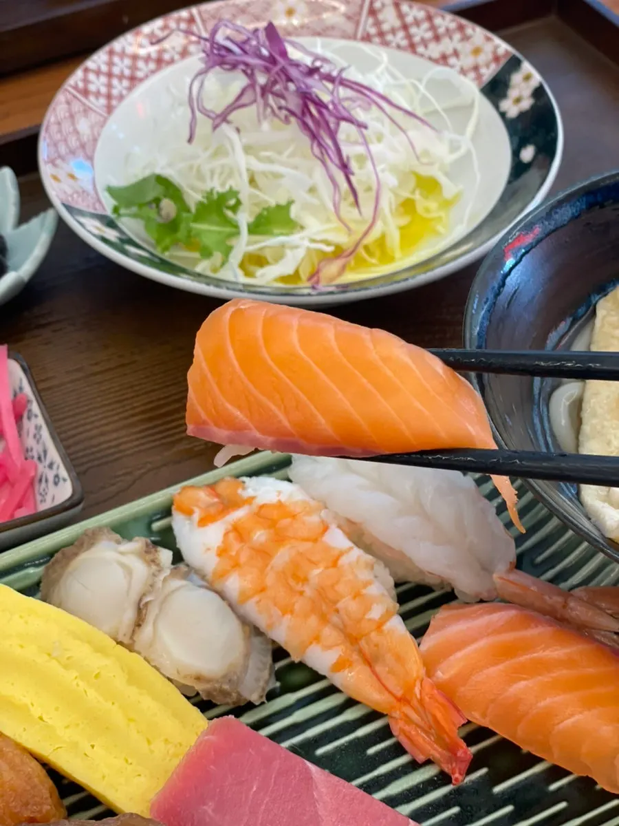 A single piece of raw sushi being picked up
