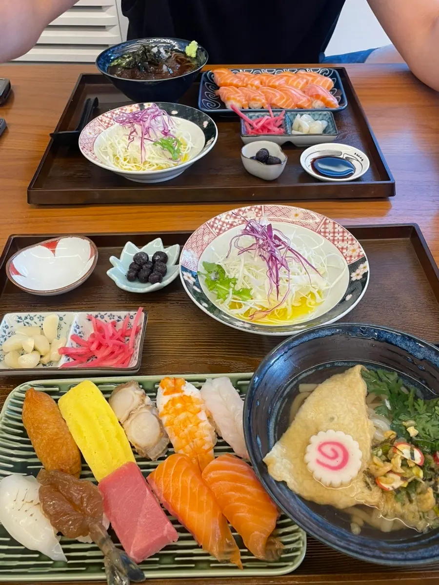 Family lunch table with sushi and noodle dishes together