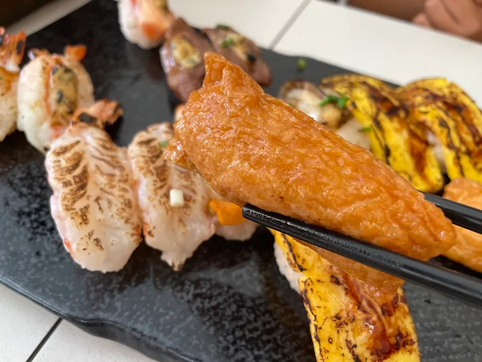 Plate of flame-seared sushi topped with sauce