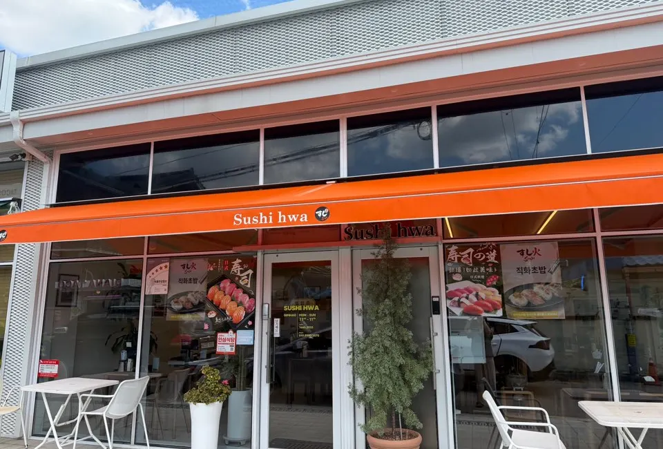Exterior of Sushi Hwa with its striking orange sign