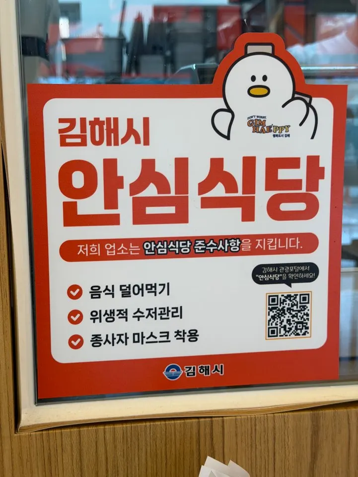 Wall sign showing Sushi Hwa's Gimhae Safe Restaurant designation