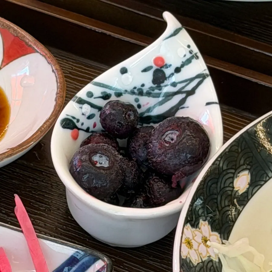 Pickled radish, pickled ginger, and frozen blueberries on a plate