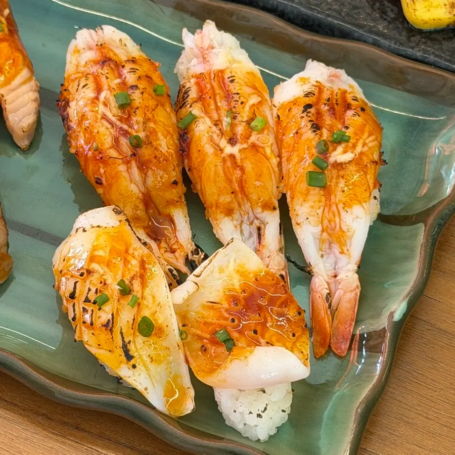 Garlic flame sushi served in a black bowl