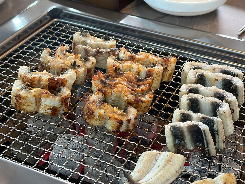 Eel turning golden brown over the charcoal fire