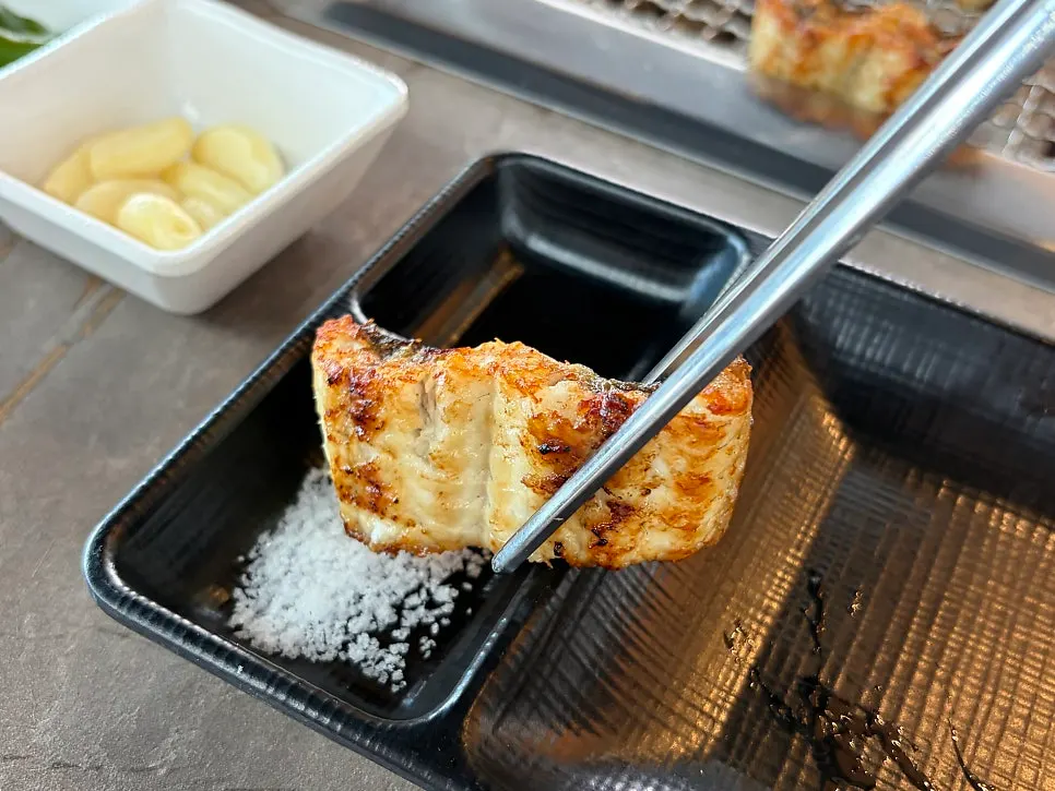 Picking up a fully cooked piece of eel