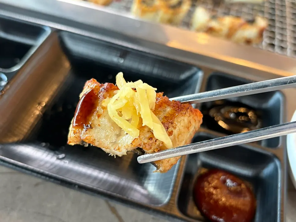 A piece of charcoal-grilled eel dipped in salt