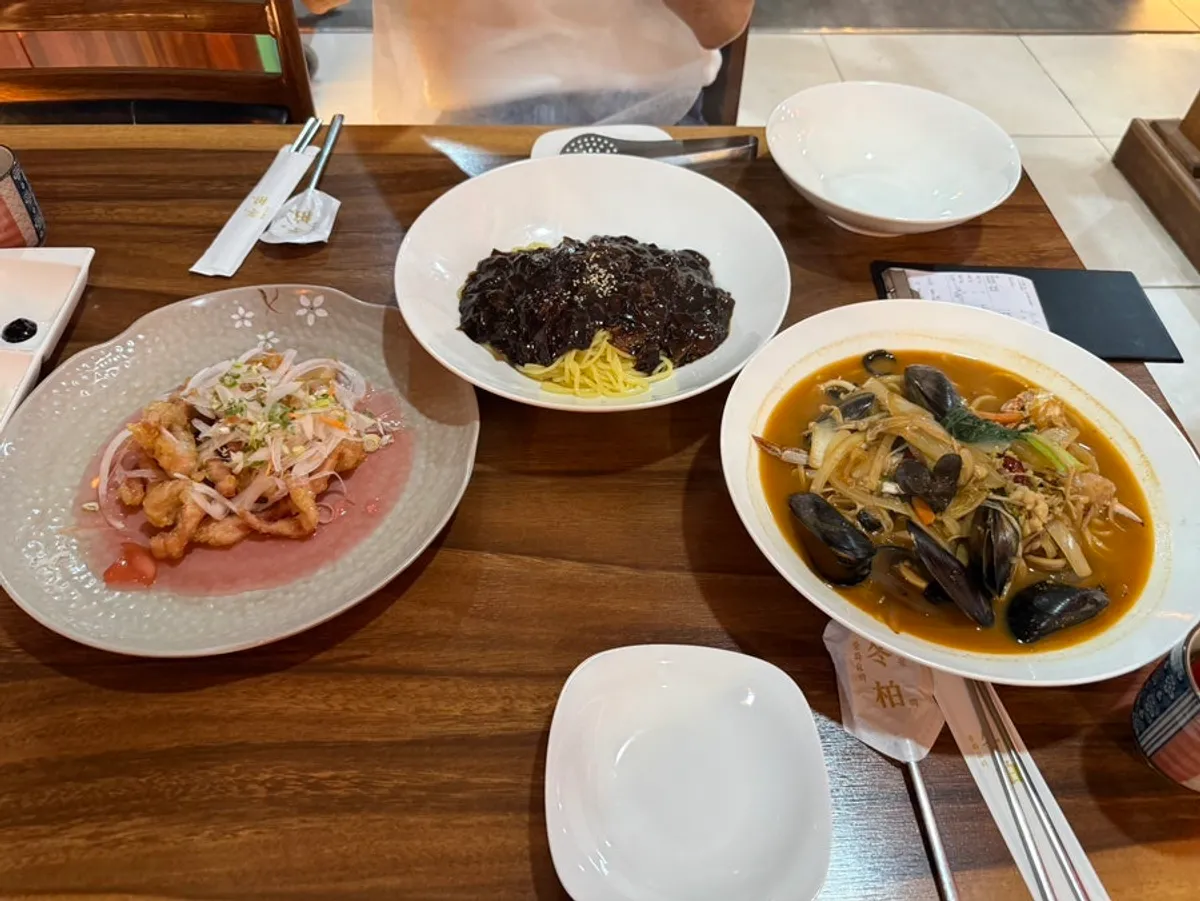 Table set with tangsuyuk, seafood jjamppong, and jjajangmyeon