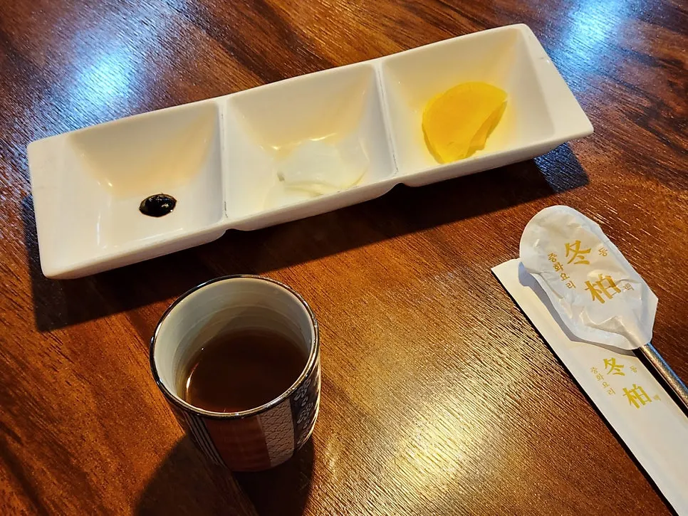 Basic side dishes: jasmine tea, pickled radish, onion, and chunjang