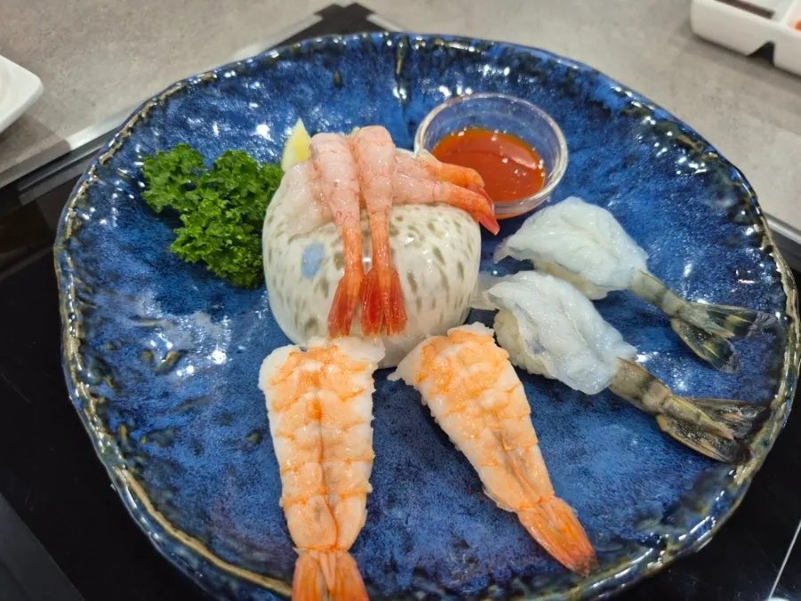 Side dish plate of salad and shrimp sushi