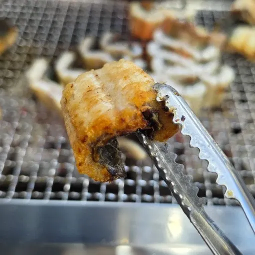 Savory fat rendering off the eel over charcoal