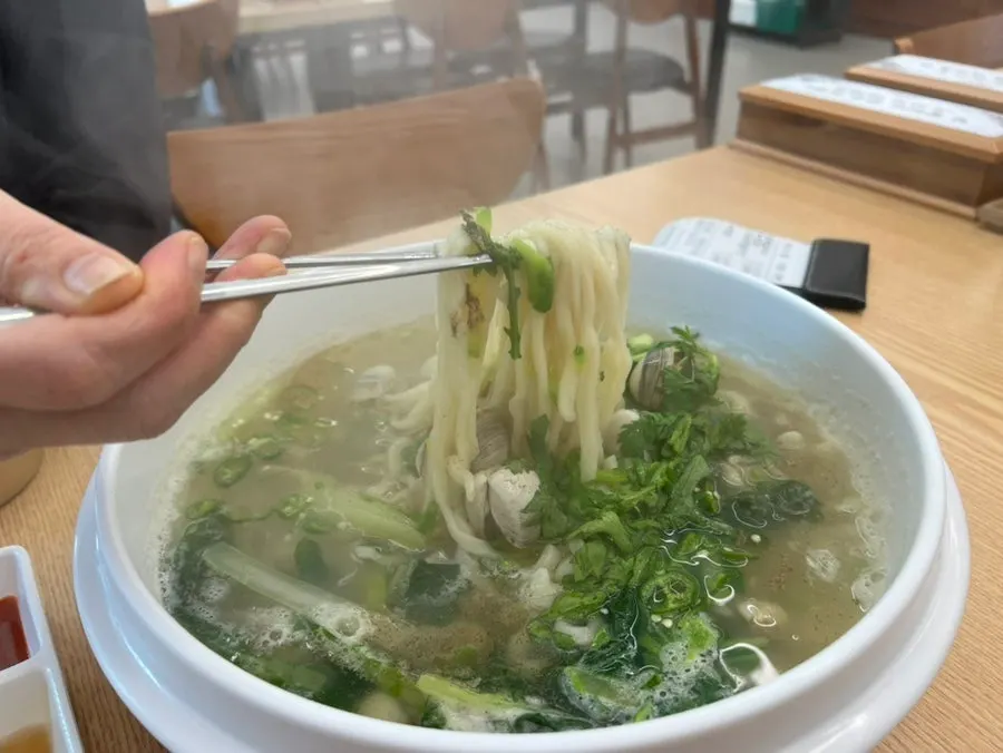 Kalguksu topped with crown daisy garnish