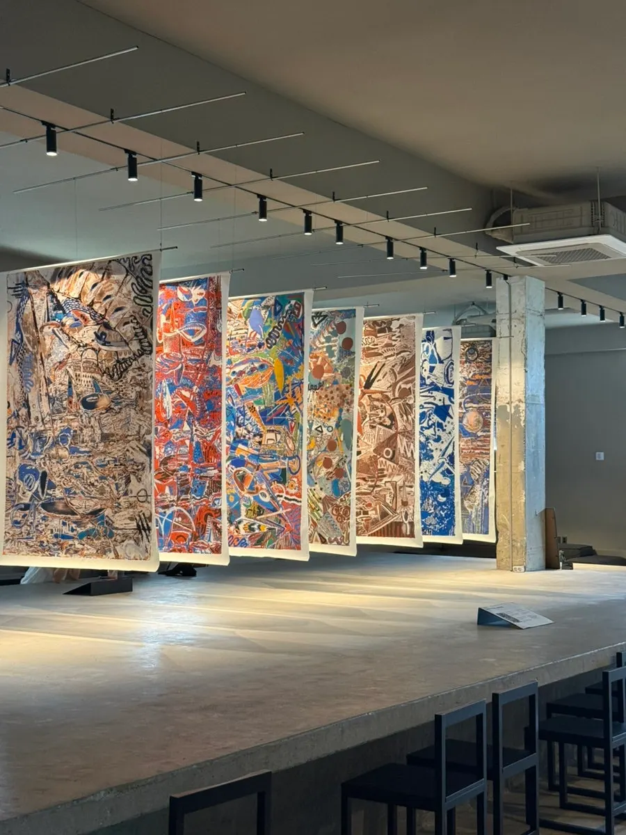Left-side exhibition and seating area with artwork on the wall